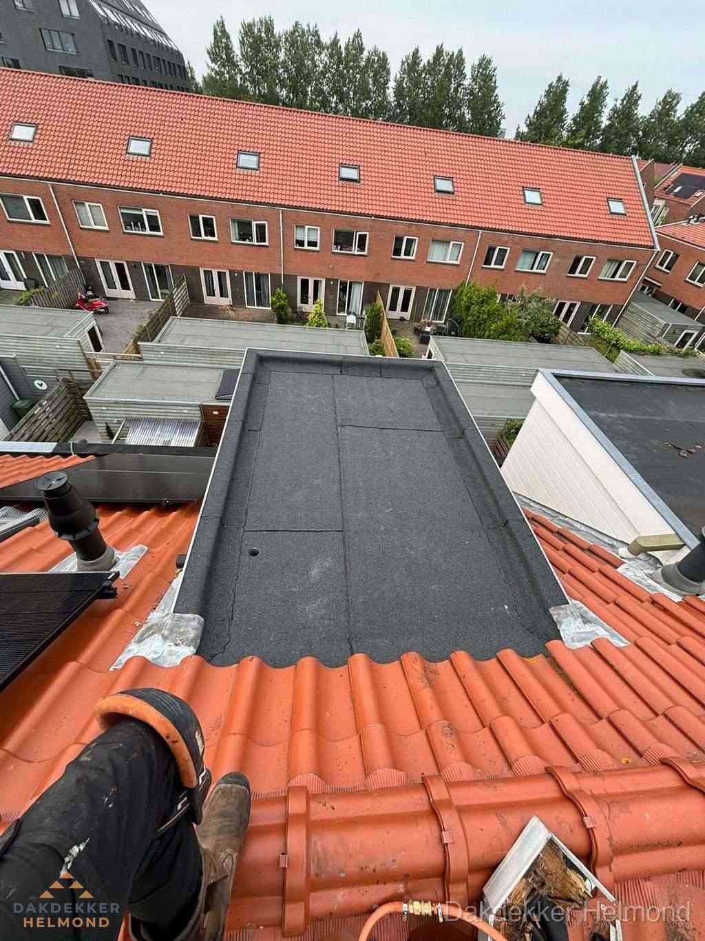 Bitumen dak reparatie op plat dak tussen dakpannen in Helmond