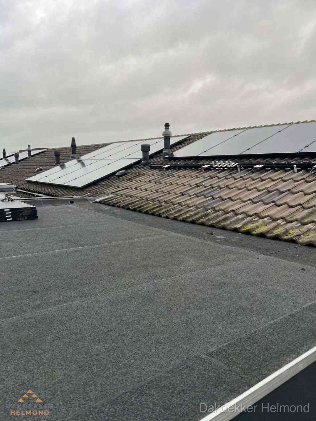 Plat dak inspectie met bitumen bedekking naast schuin pannendak in Helmond