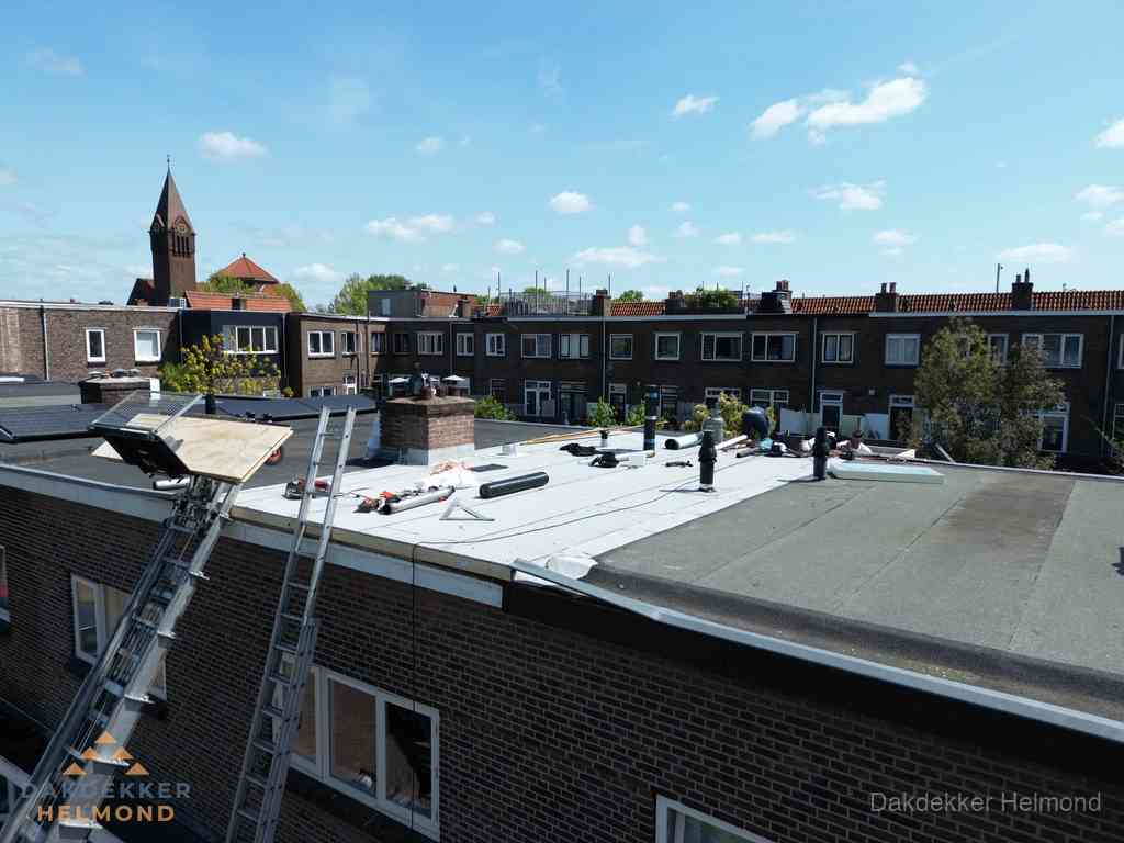 Dakdekkers aan het werk op plat dak in Helmond