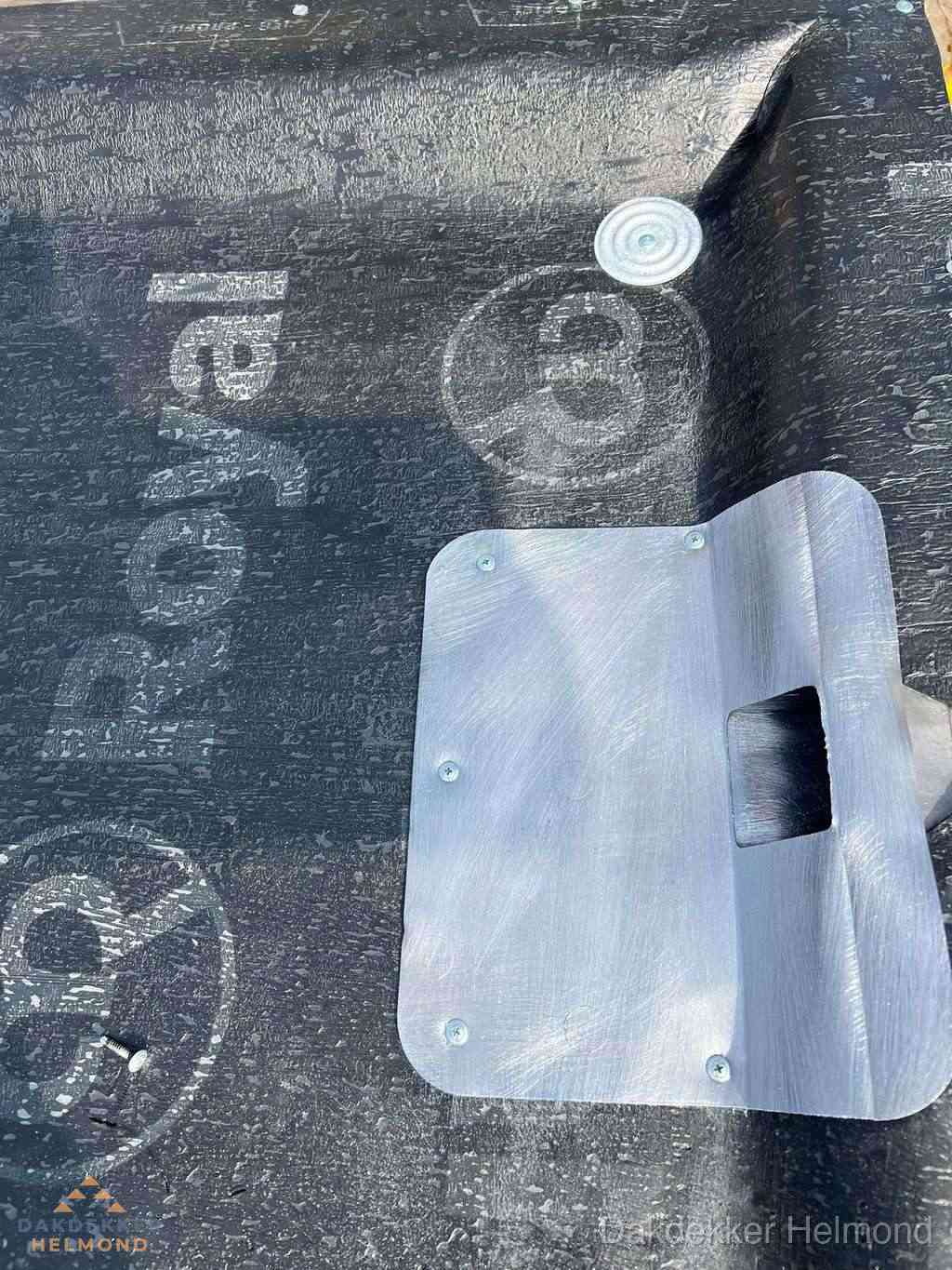 Dakdoorvoer met metalen afvoerplaat op bitumen dak in Helmond