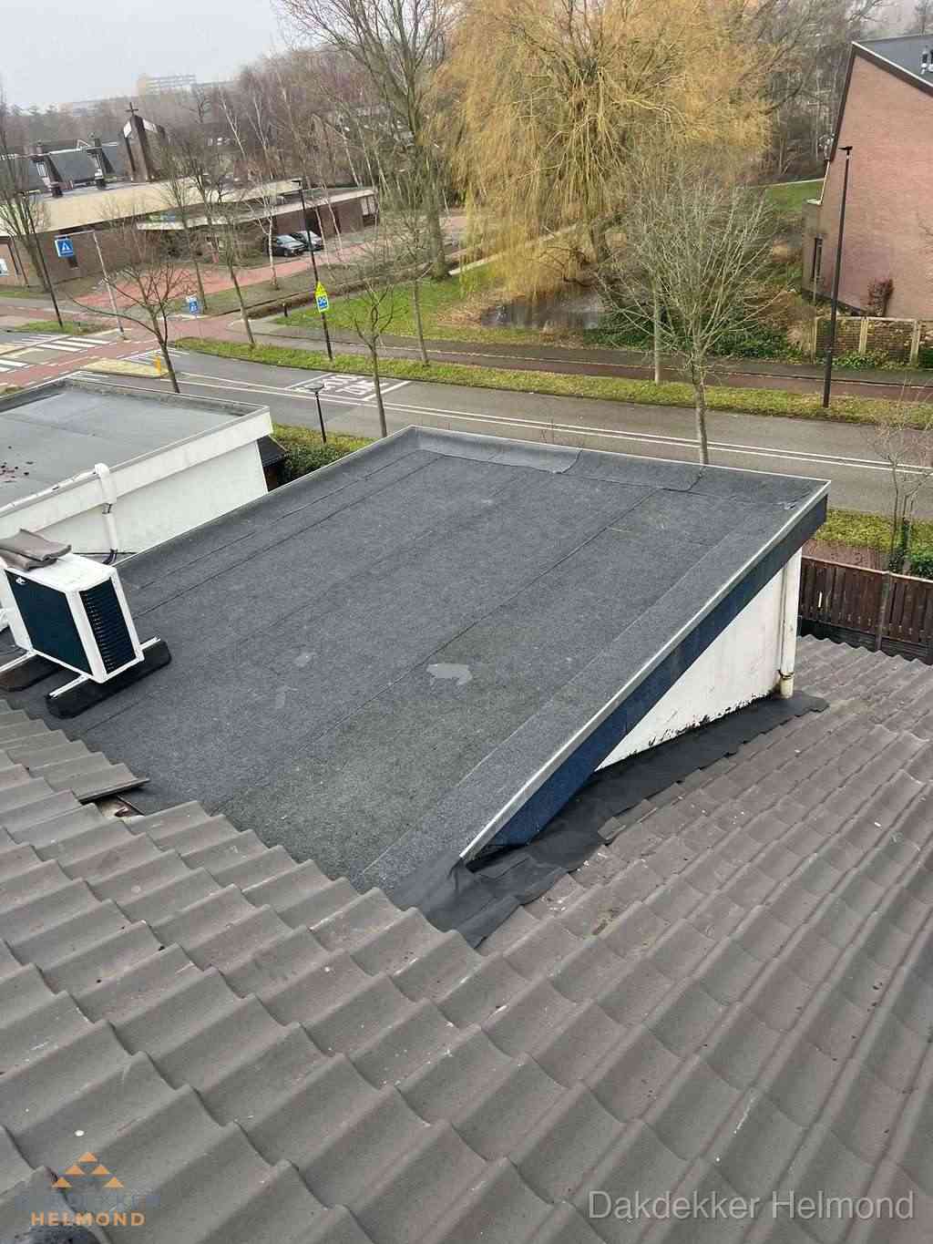 Plat dak met bitumen dakbedekking naast schuin pannendak in Helmond