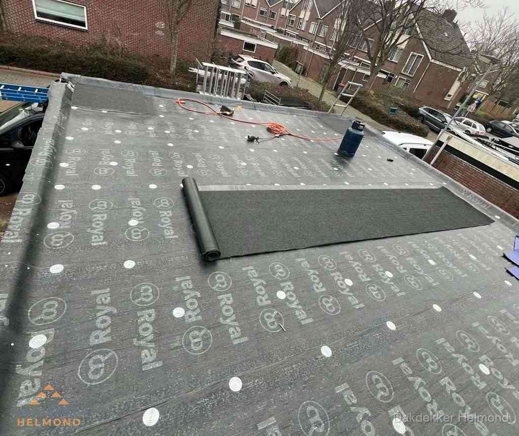 Dakdekker aan het werk met gasbrander op plat bitumen dak in Helmond